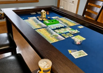 Board Game Table with Wingspan Game in Progress - Western Pride Woodworks Wingspan board game set up inside a dark stained hard maple gaming table with a blue neoprene surface.